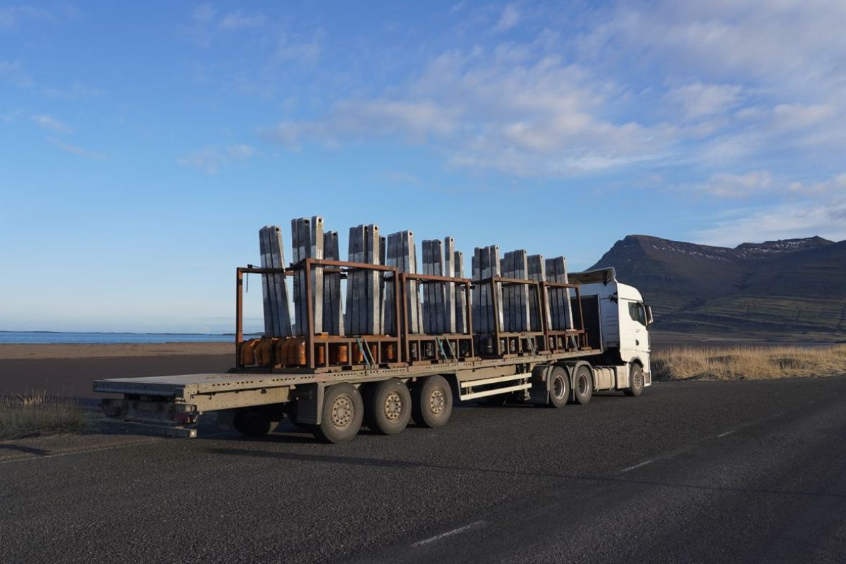 Camión con una carga larga de acero en una ruta de montaña