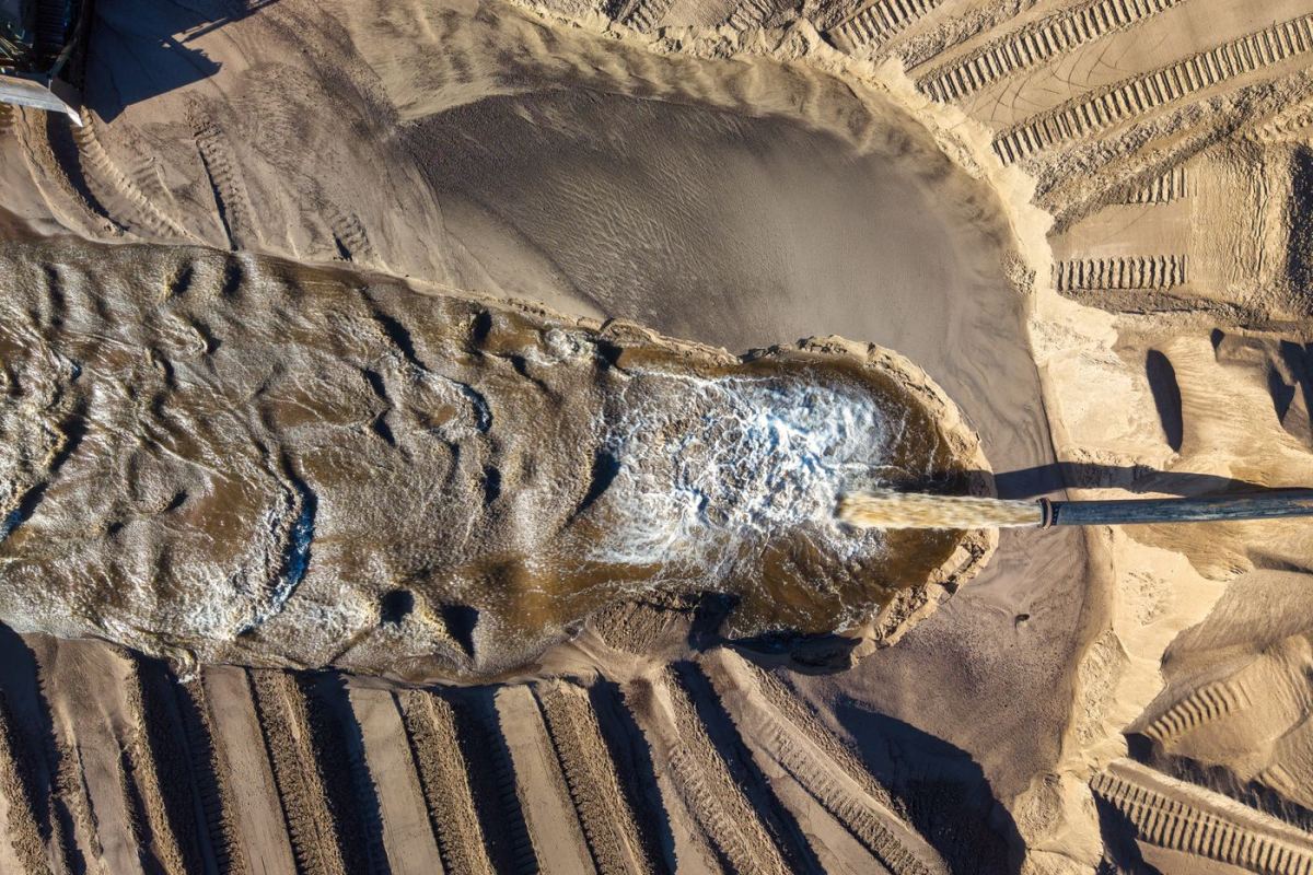 Sand mining operation with machinery, aerial view
